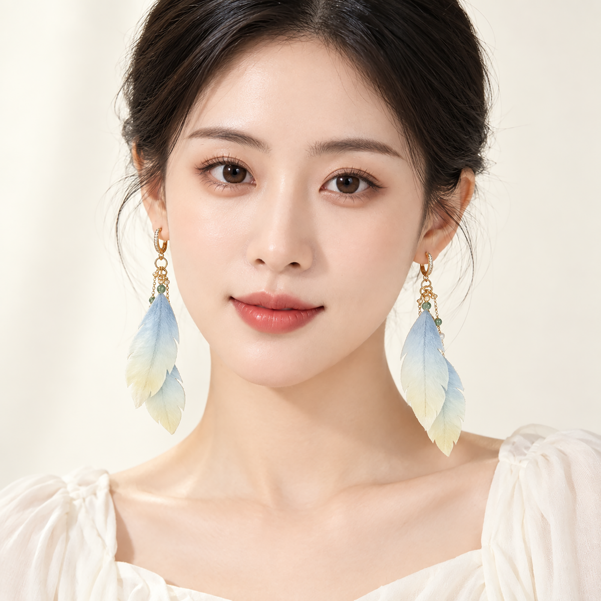 Woman wearing blue-to-ivory feather-inspired silk drop earrings
