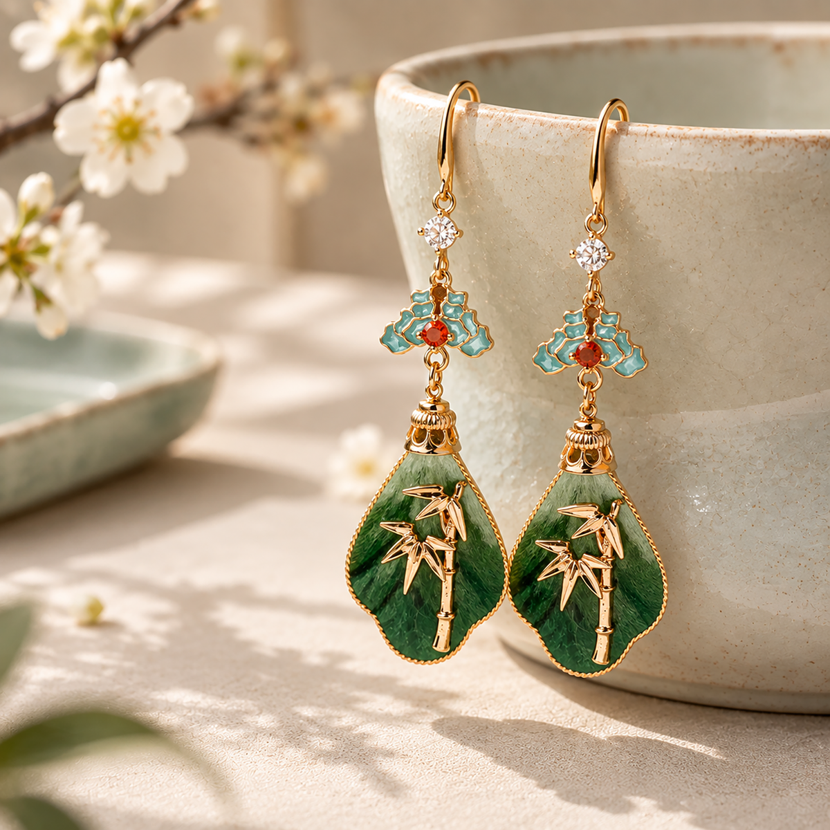 Pair of green bamboo silk velvet earrings displayed beside an ivory vase