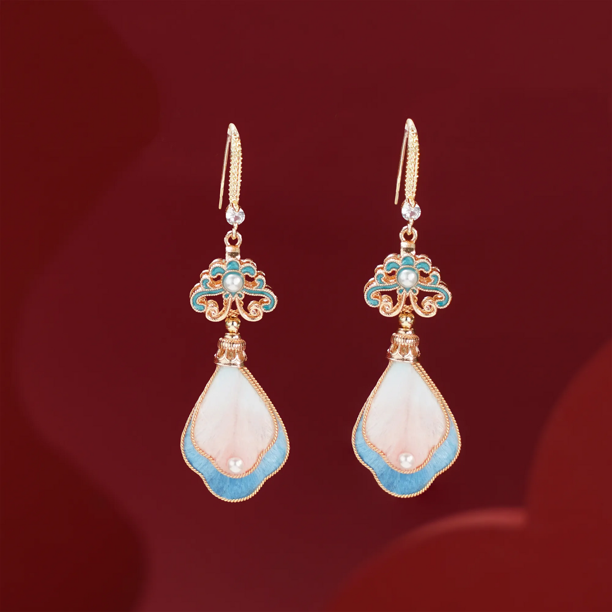 Front view of peach blossom silk velvet drop earrings on red