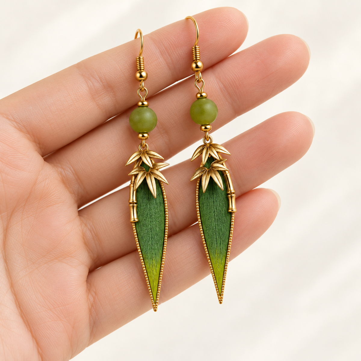 Zhuyun Qinghuan bamboo leaf earrings held in hand