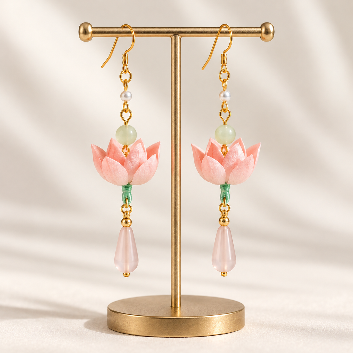 Qinghe lotus Ronghua drop earrings on a display stand