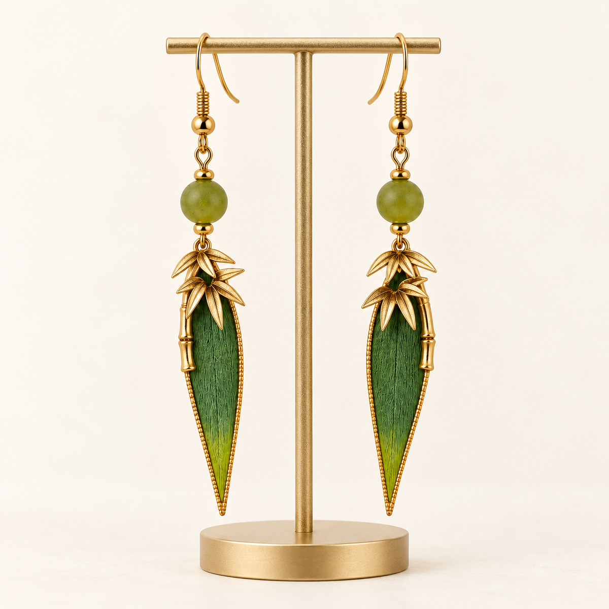 Green bamboo leaf earrings on a display stand
