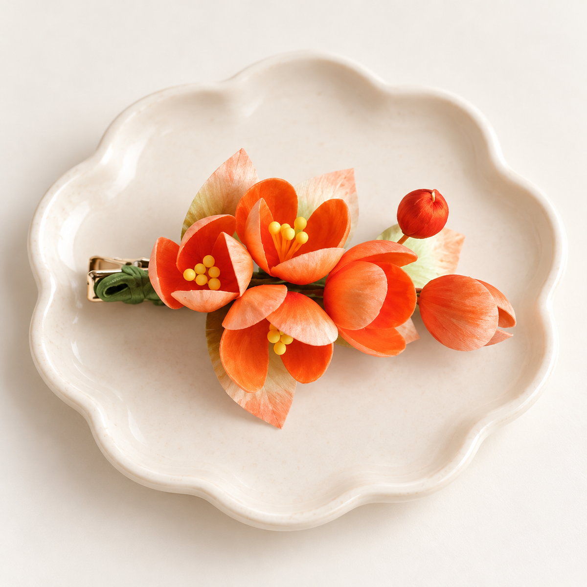 Orange blossom hair clip on a ceramic plate