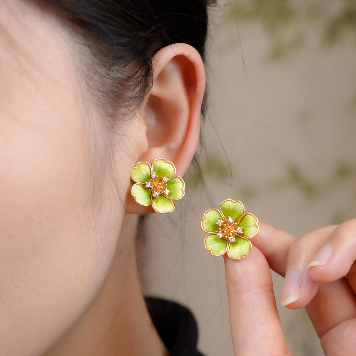 Spring Blossom green silk velvet stud earrings worn on ear with the second earring held beside it