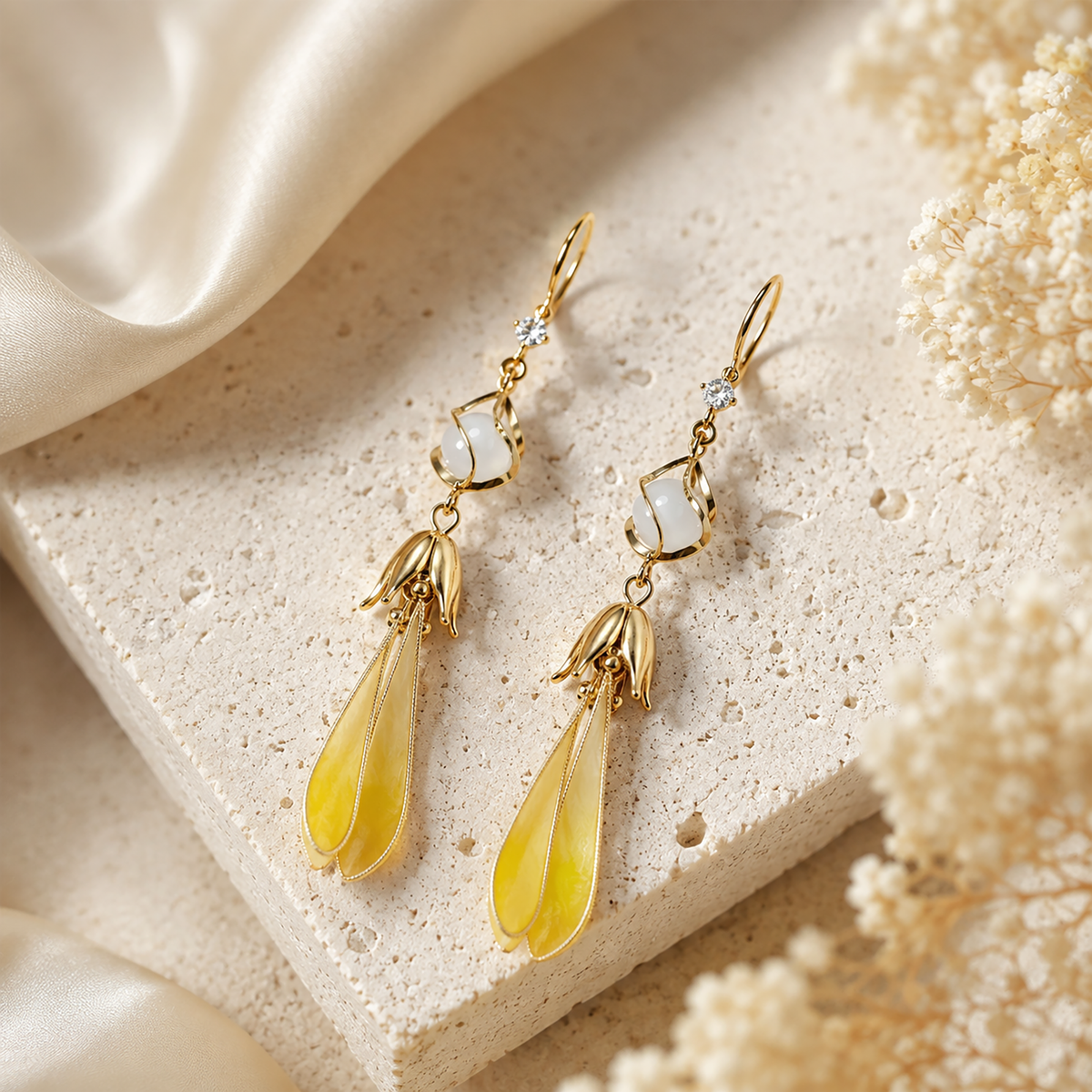 Golden Magnolia drop earrings with silk velvet petals and gold-tone metalwork on stone display