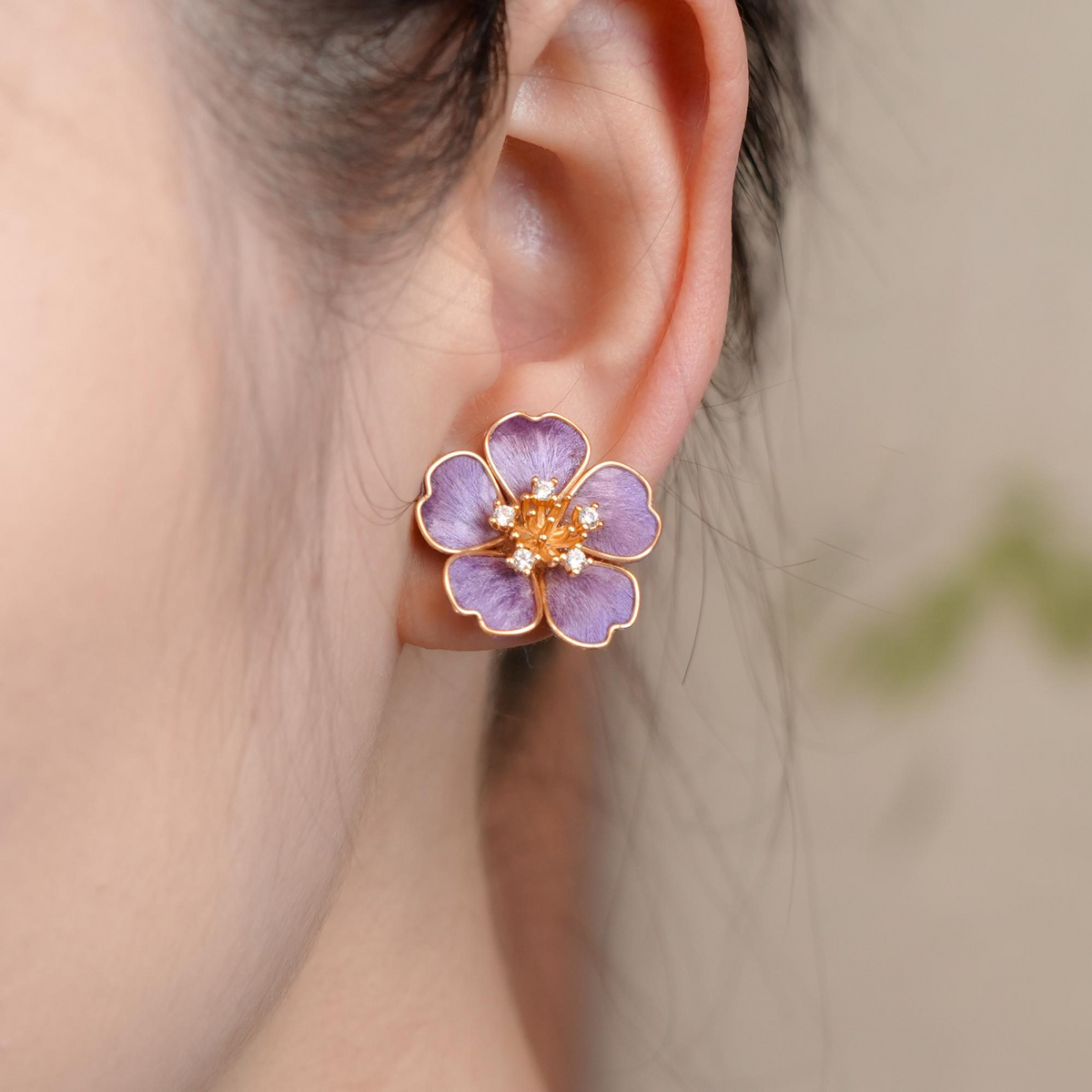Close-up of Violet Blossom silk velvet flower stud earring worn on the ear