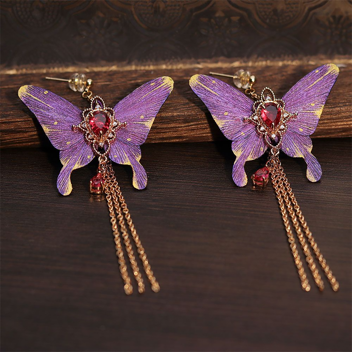 Side view of purple butterfly earrings and suspended tassels