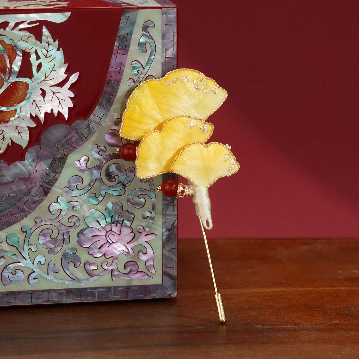 Ginkgo Ronghua wirework stickpin brooch beside a decorative screen