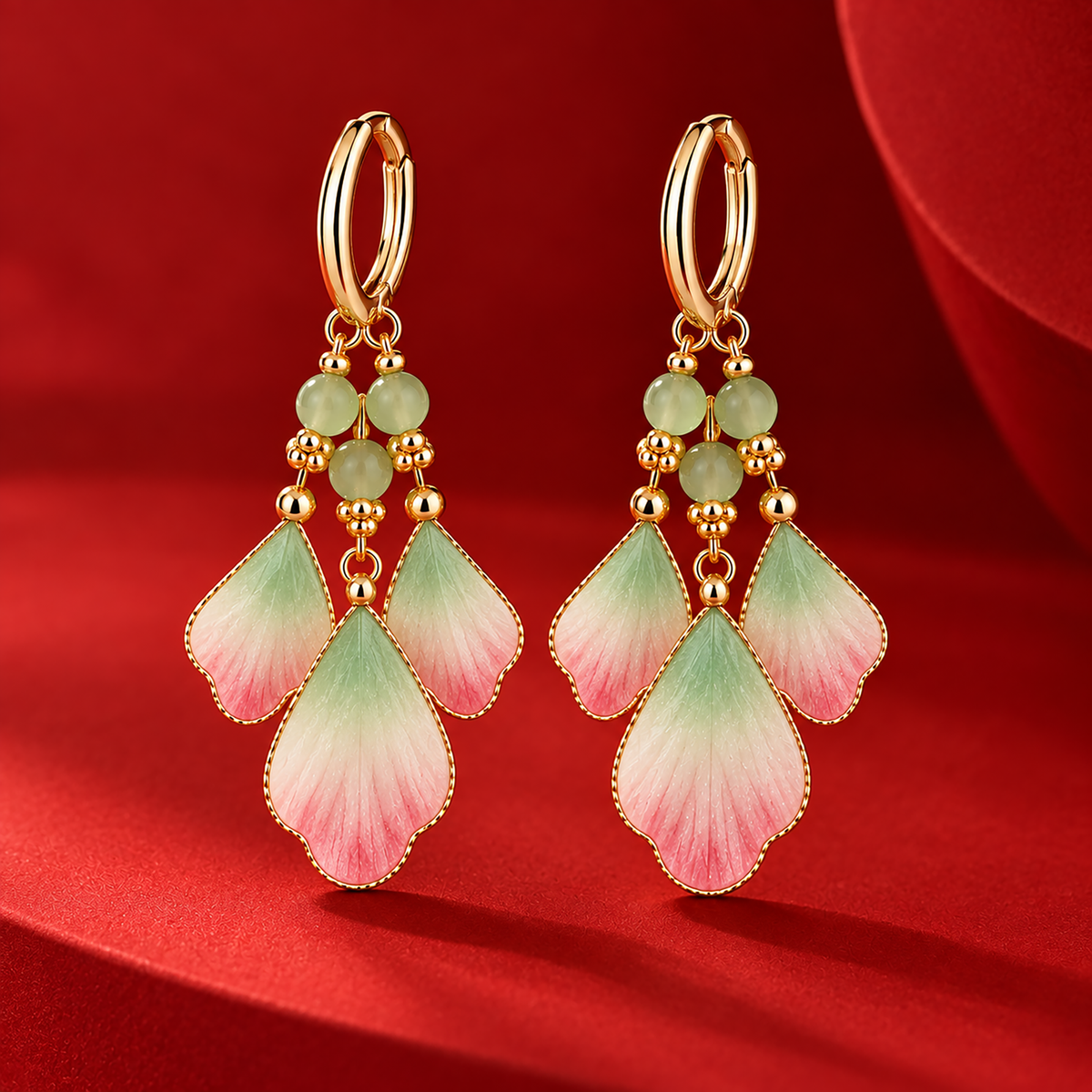 Three pink, ivory and green silk petals suspended from each gold-tone hoop on a red plinth