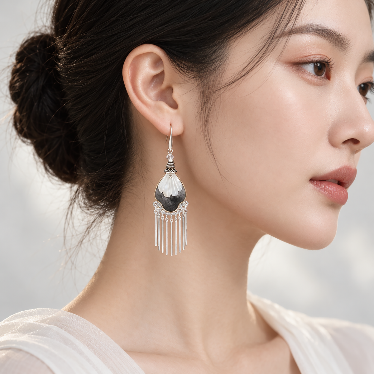 Black and ivory silk teardrops with silver-tone fringe worn beside the face