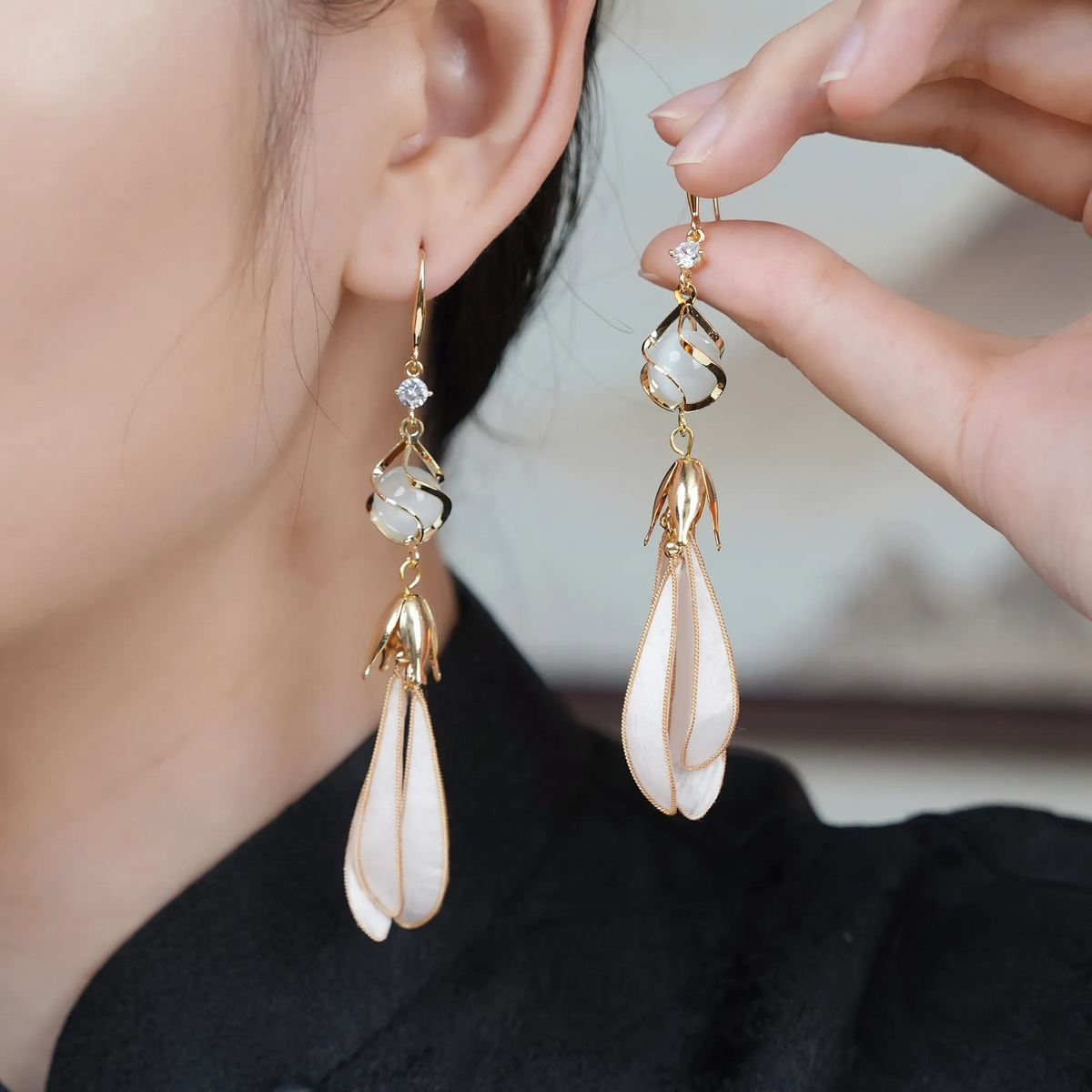 White magnolia silk velvet drop earrings worn by a model