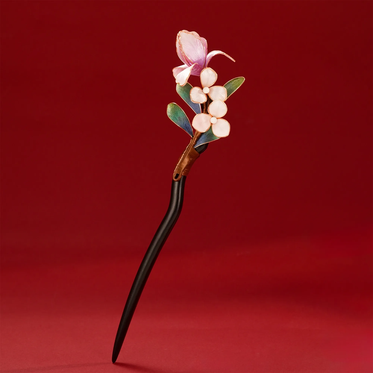 Upright view of pink butterfly blossom hairpin on red