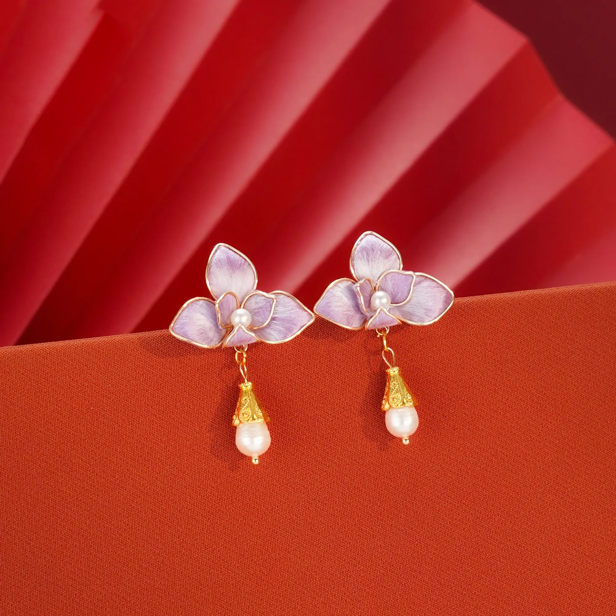 Purple butterfly orchid silk velvet earrings on folded paper