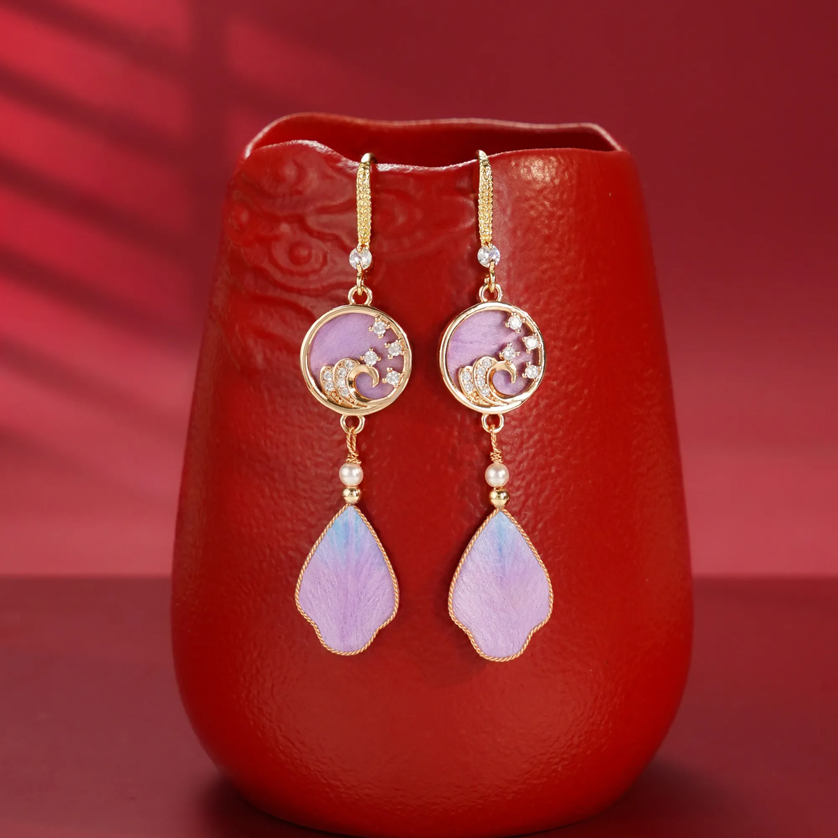 Purple rosy cloud silk velvet drop earrings displayed with a red vase