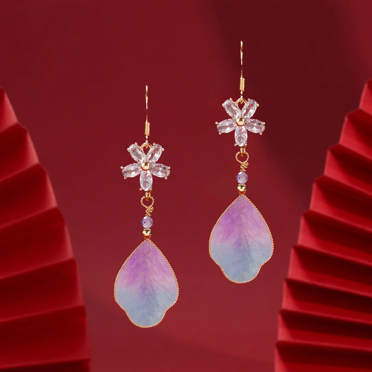 Front view of purple cloud silk velvet earrings on red