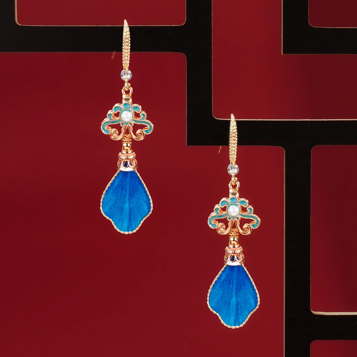 Blue silk velvet drop earrings displayed on a dark background