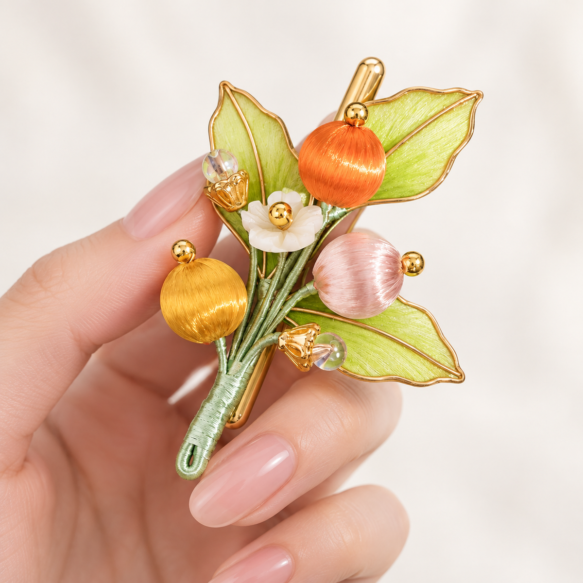 Orchard berry Ronghua brooch held in hand for scale