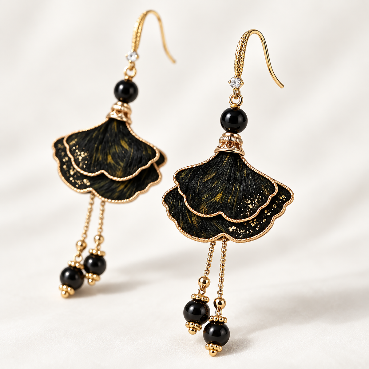 Ink-dyed ginkgo silk drop earrings on cream background