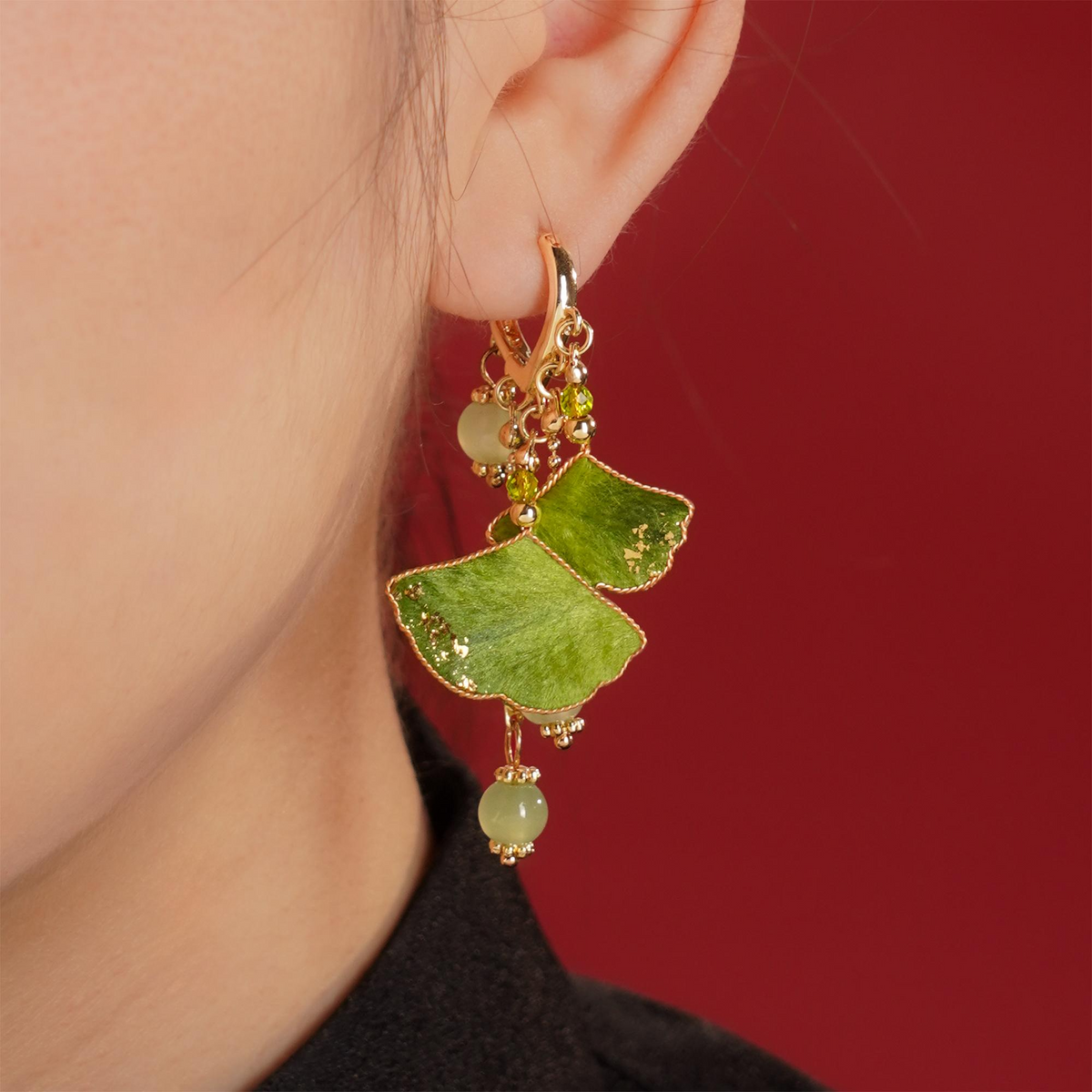 Woman wearing green ginkgo silk velvet dangle earrings by CLMADE