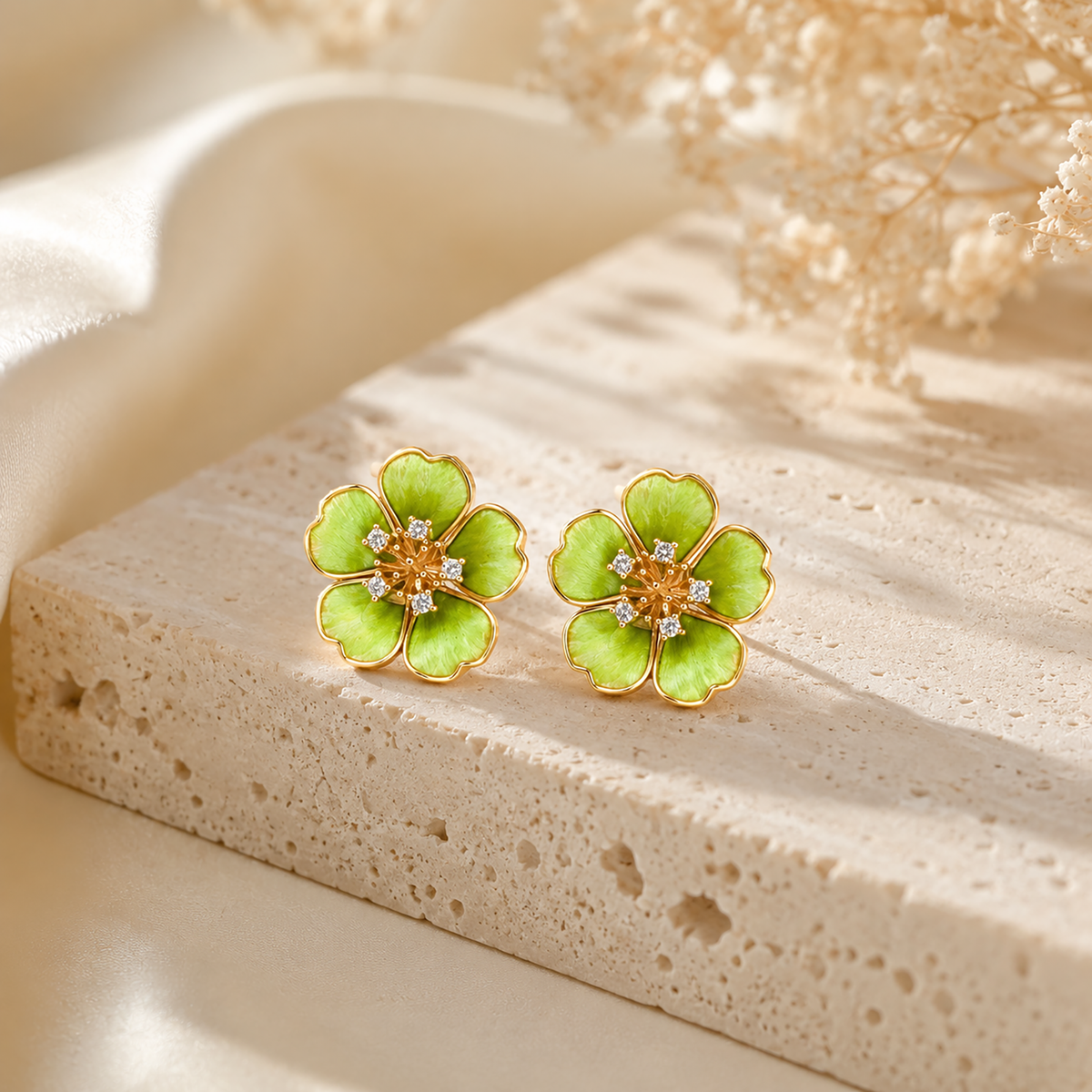 Pair of green flower silk velvet stud earrings with gold-tone edges on cream stone