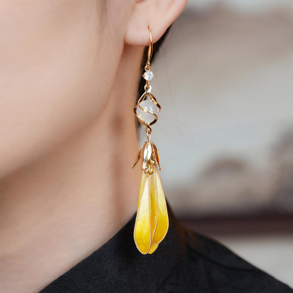 Golden Magnolia silk velvet drop earring worn on ear with white bead and crystal detail