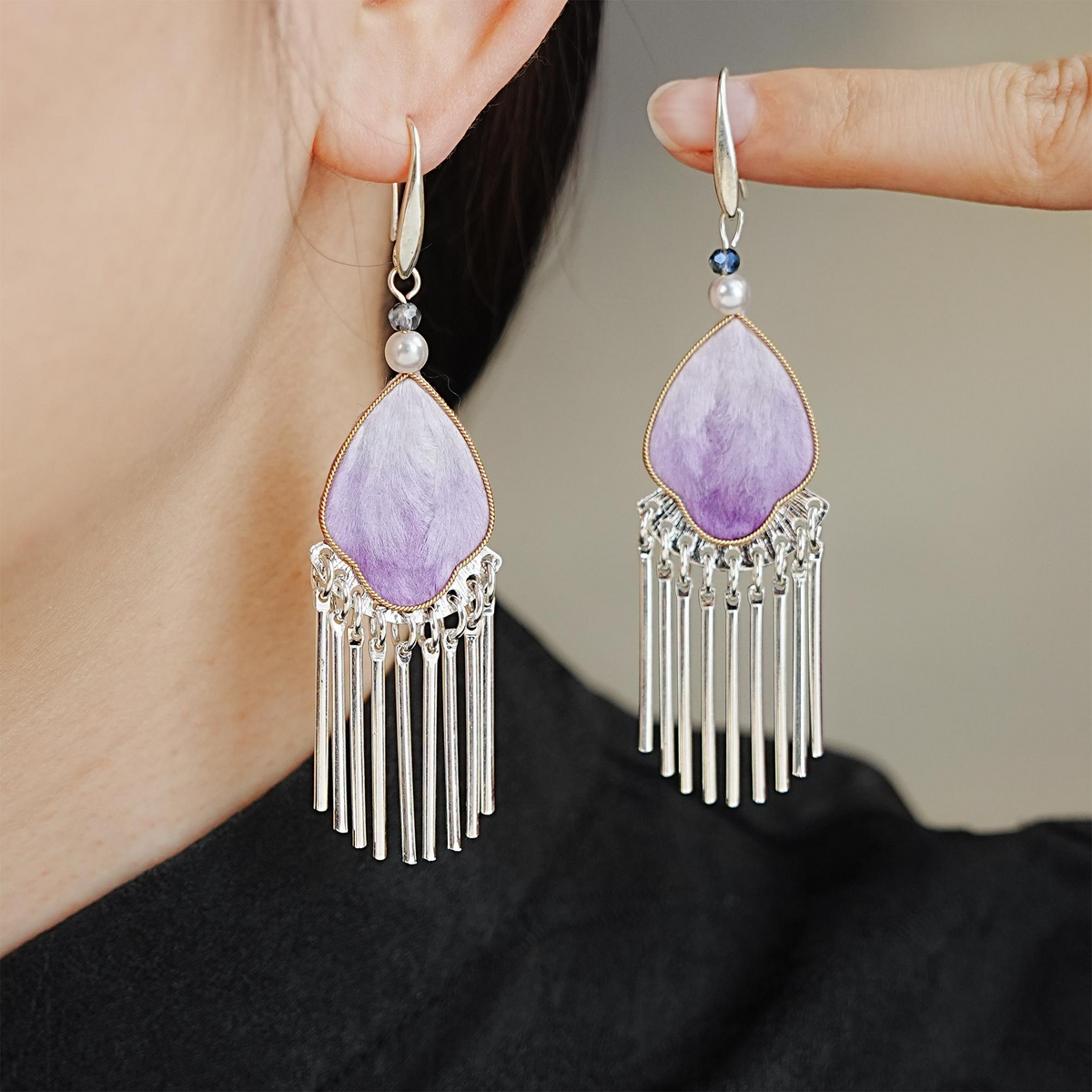 Model wearing violet silk velvet tassel earrings with pearl accents and silver-tone fringe