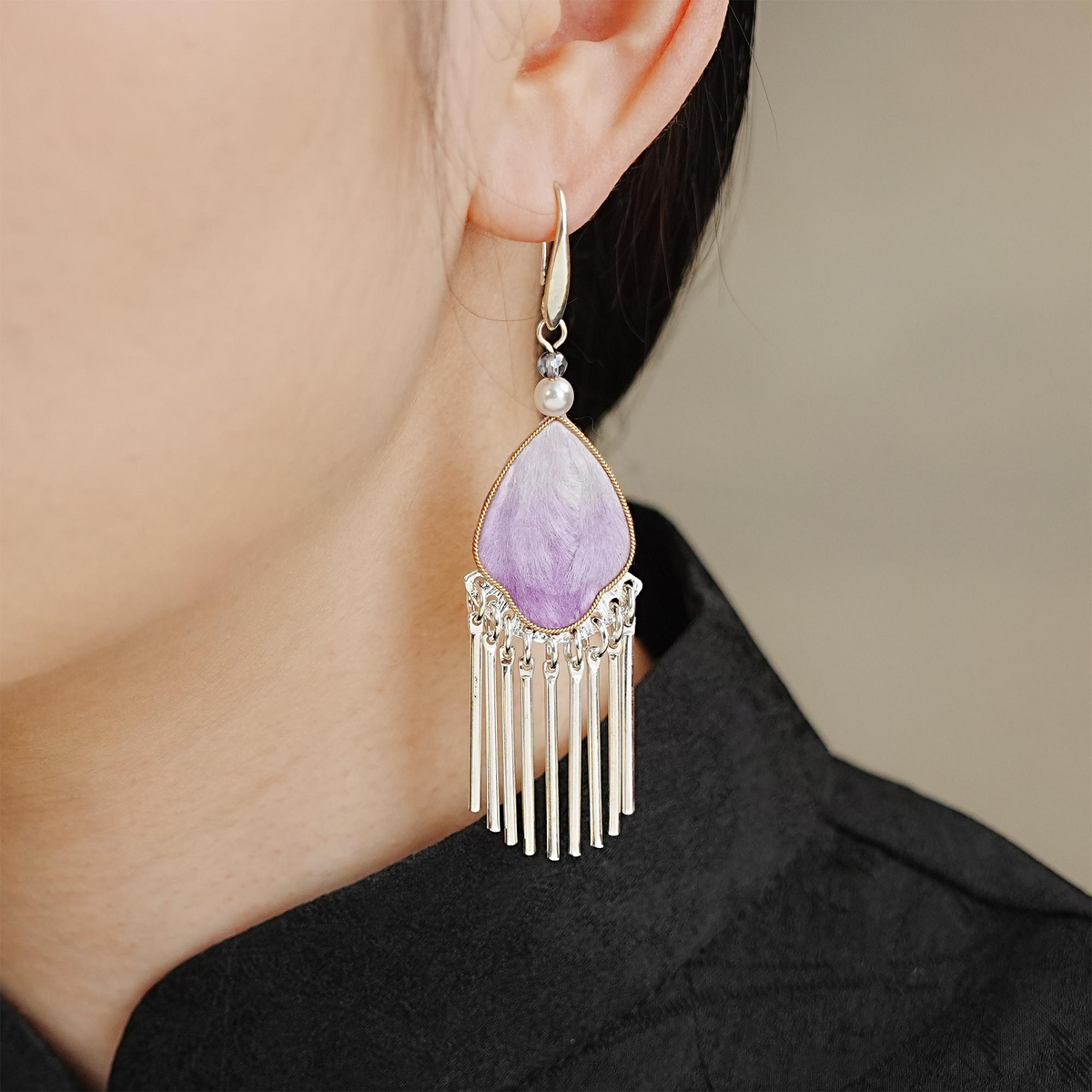 Close-up of Violet Petal silk velvet tassel earring worn on ear