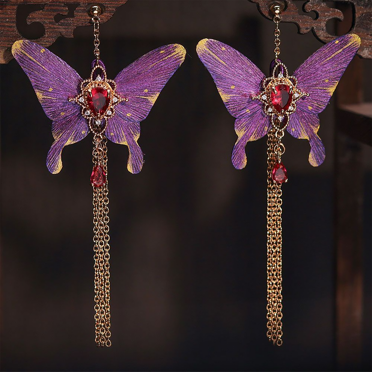Purple butterfly earrings with long chain tassels on display