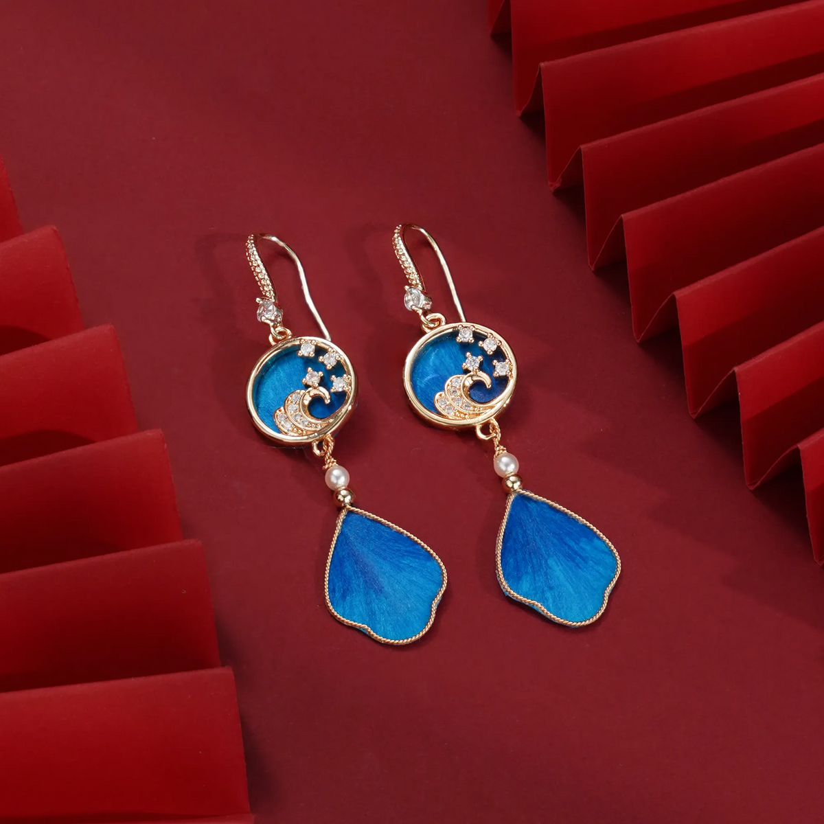 Blue Ronghua hook earrings with wave medallions on red paper