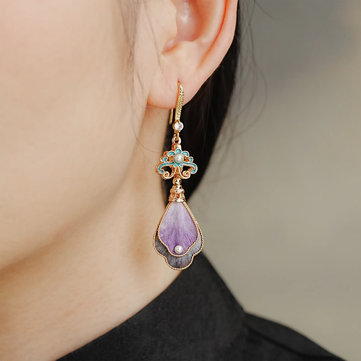 Close-up of a lavender silk velvet drop earring with turquoise wirework detail