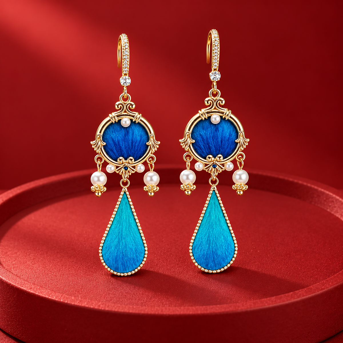 Blue circular silk motifs and turquoise teardrops in gold-tone frames on a red plinth