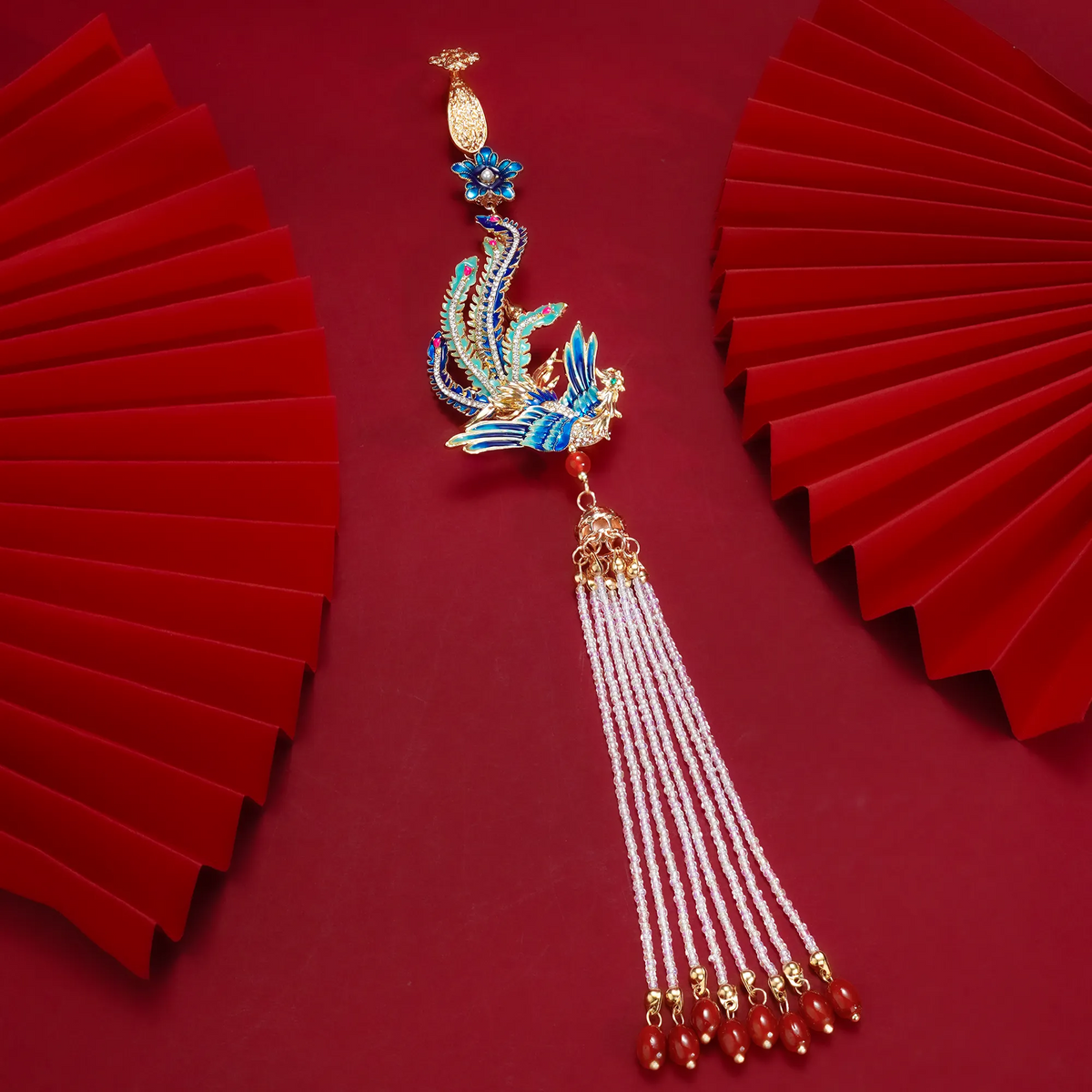 Phoenix Arrival Brooch with tassel on a red background
