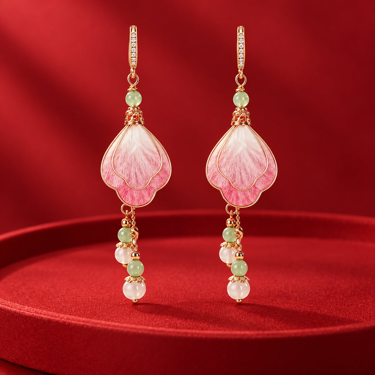 Layered pink and ivory silk petals with green and white bead drops on a red plinth